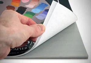 person thumbing through a paint palette book